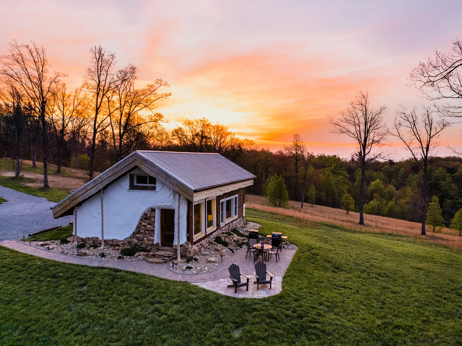 A small building and patio under a sunset sky.