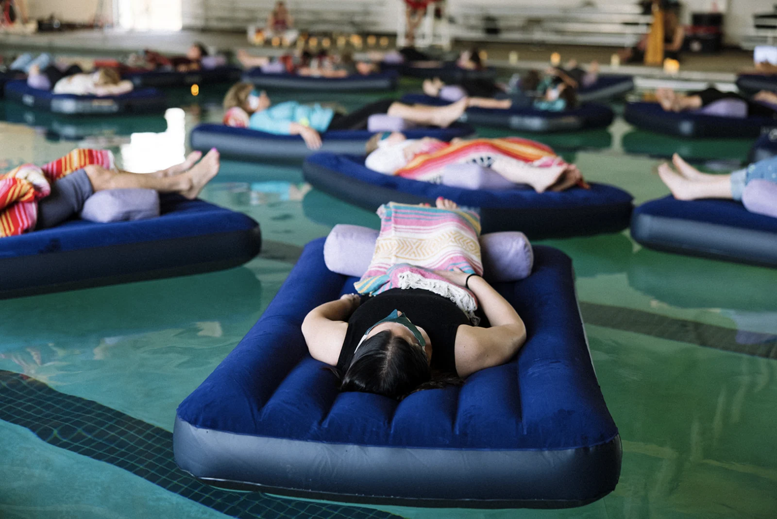 Floating sound bath participants in a pool.